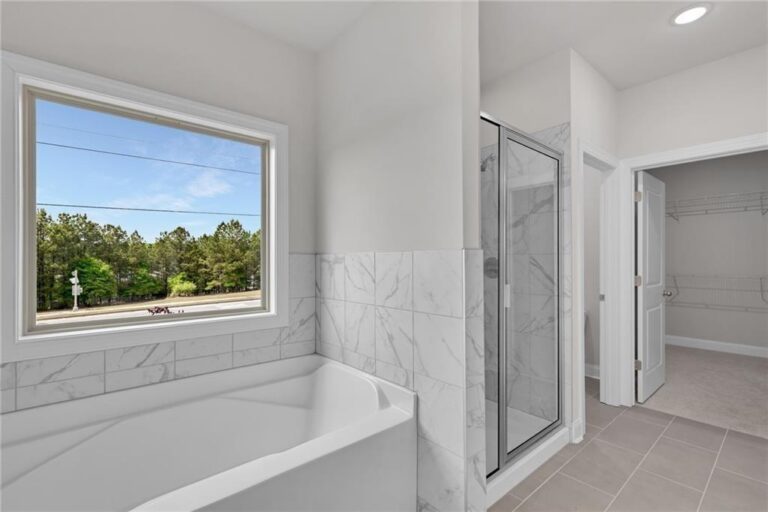 Owner’s bath with soaking tub and tile shower at Parkview Landing